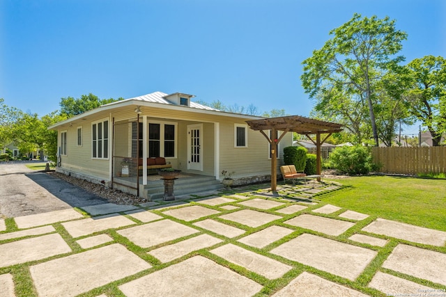 rear view of property featuring a yard and a pergola