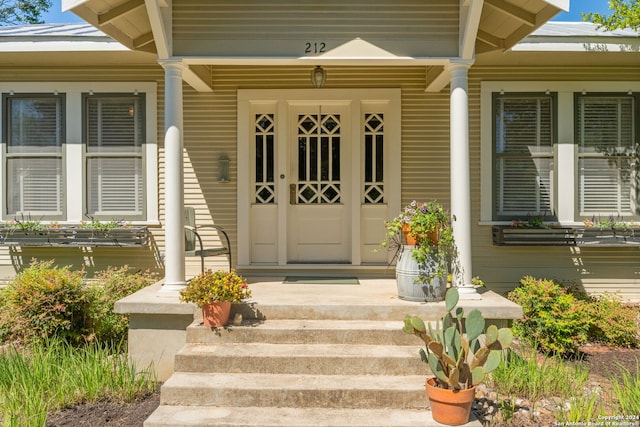 view of exterior entry featuring covered porch