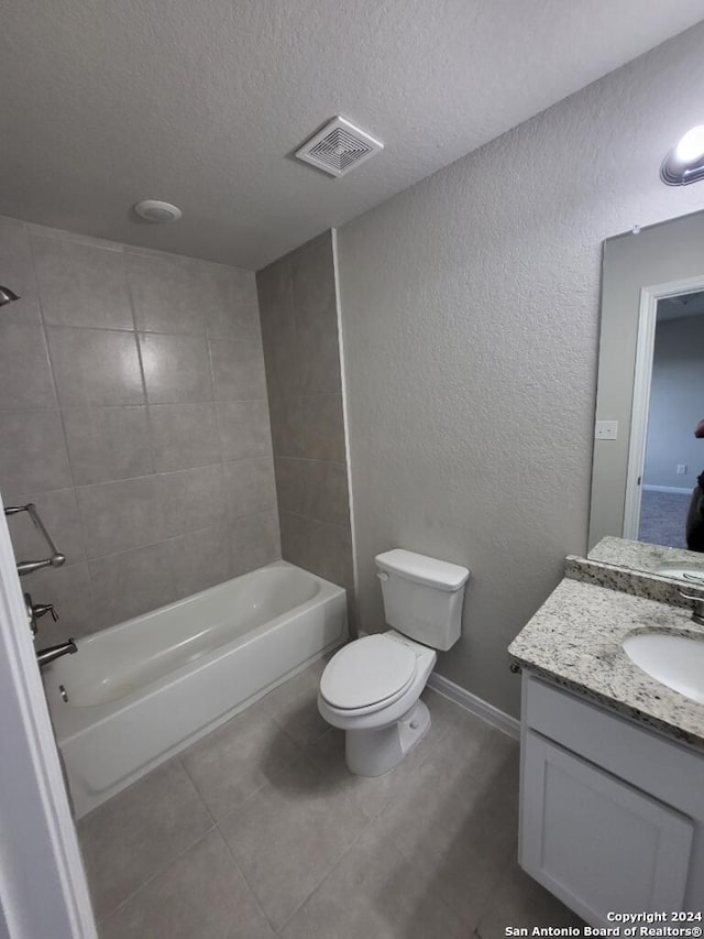 full bathroom featuring toilet, tiled shower / bath, tile flooring, a textured ceiling, and vanity