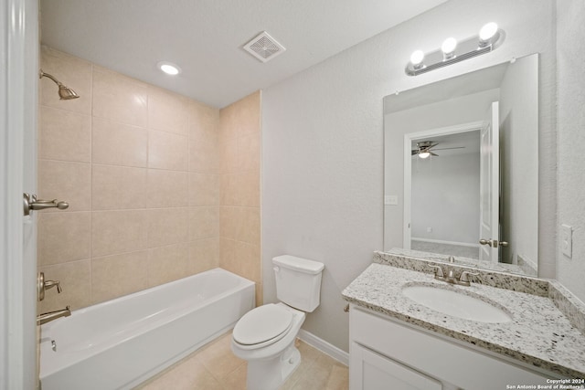 full bathroom with tiled shower / bath combo, ceiling fan, tile flooring, toilet, and oversized vanity