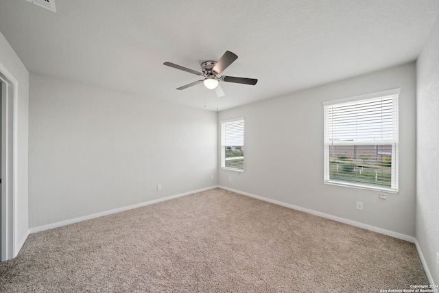 empty room featuring ceiling fan and light colored carpet