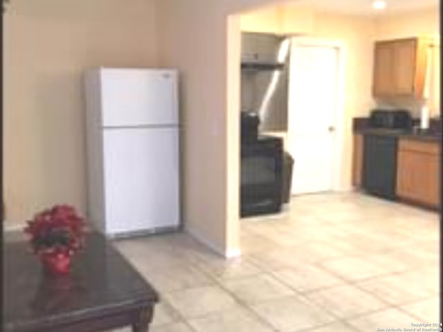 kitchen featuring white fridge and light tile floors