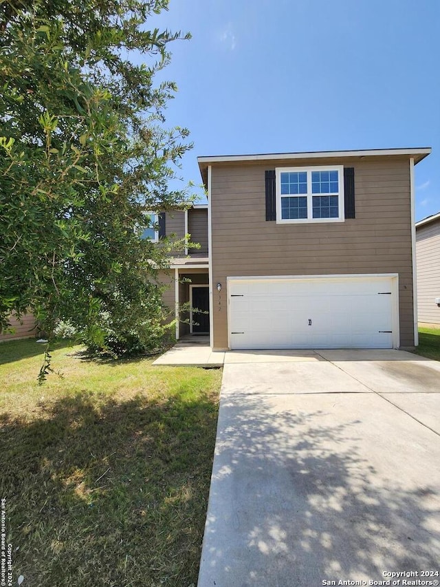 view of front of property with a garage and a front lawn