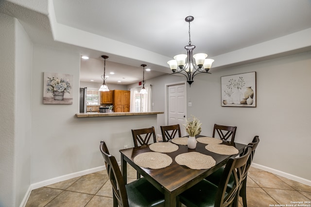 tiled dining room with a chandelier