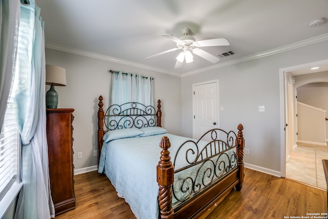 bedroom featuring ceiling fan, ornamental molding, and hardwood / wood-style floors