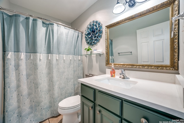 bathroom with toilet and vanity with extensive cabinet space