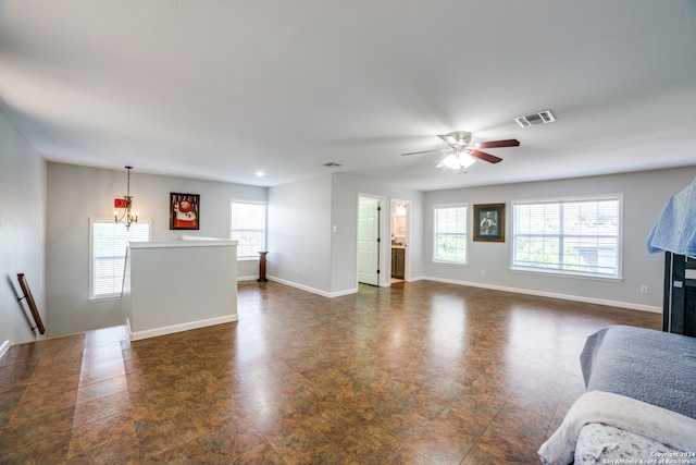 living room featuring dark tile flooring and ceiling fan with notable chandelier