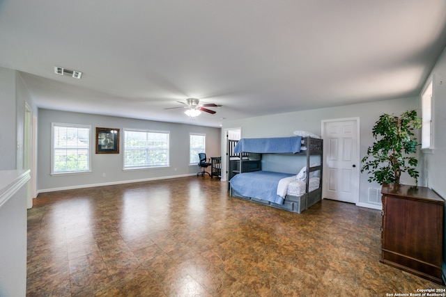 bedroom featuring ceiling fan and dark tile floors