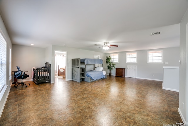 interior space with ceiling fan and dark tile flooring