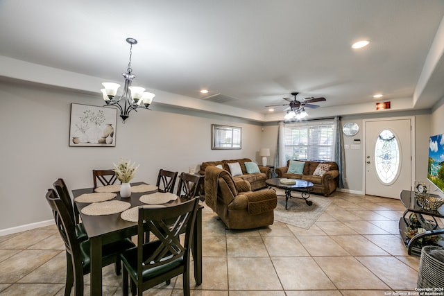 tiled dining room with ceiling fan with notable chandelier