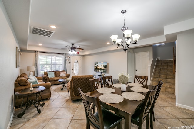 tiled dining area with ceiling fan with notable chandelier