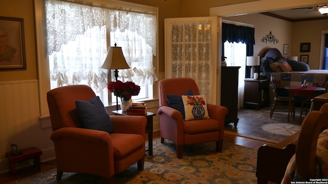 living area with ceiling fan, ornamental molding, and dark hardwood / wood-style floors