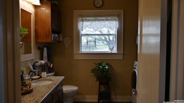 bathroom featuring large vanity, washer / clothes dryer, and toilet