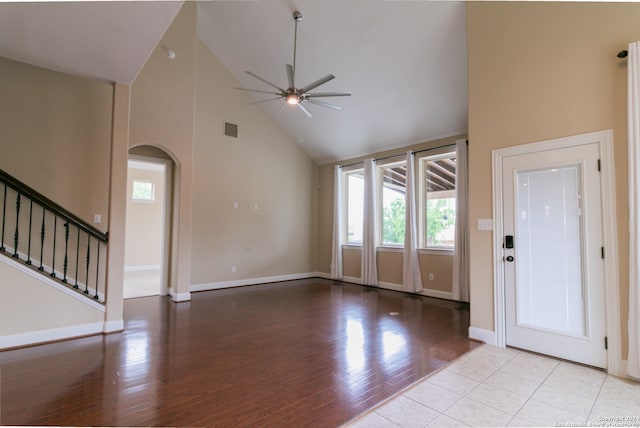 tiled foyer entrance with ceiling fan and high vaulted ceiling