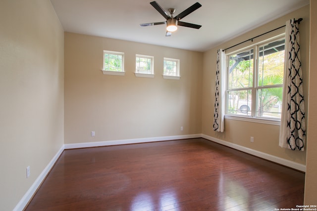 unfurnished room featuring dark hardwood / wood-style flooring, ceiling fan, and a wealth of natural light