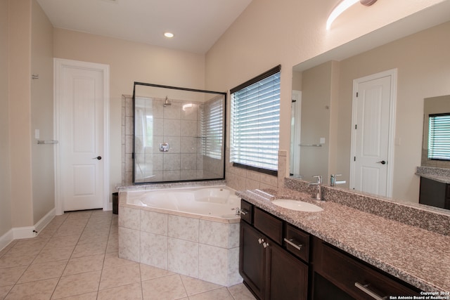 bathroom with a relaxing tiled bath, vanity, and tile flooring