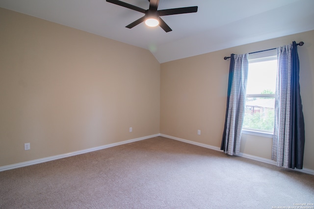 empty room featuring light carpet, vaulted ceiling, and ceiling fan