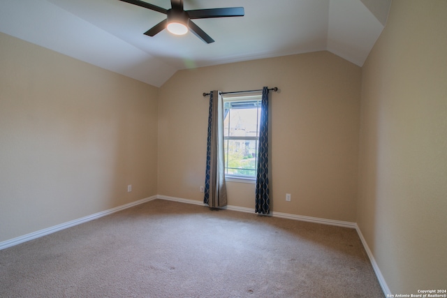 carpeted empty room with vaulted ceiling and ceiling fan