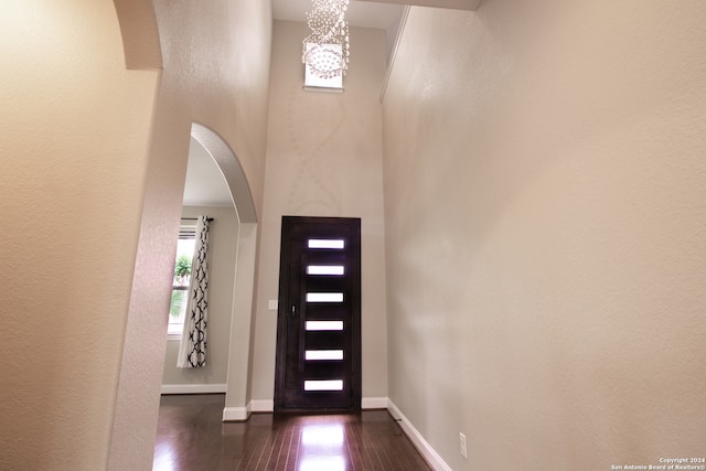 entrance foyer featuring a high ceiling, dark wood-type flooring, and an inviting chandelier