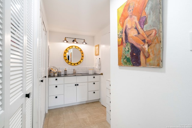 bathroom featuring tile patterned flooring, vanity, and tasteful backsplash