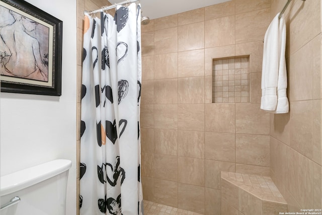 bathroom featuring curtained shower and toilet