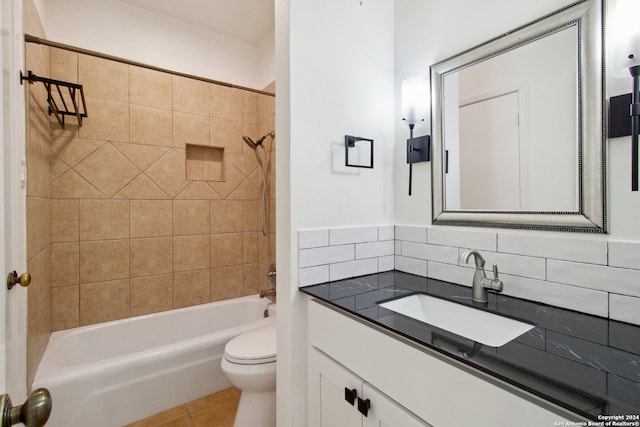 full bathroom with decorative backsplash, vanity, tiled shower / bath, tile patterned flooring, and toilet