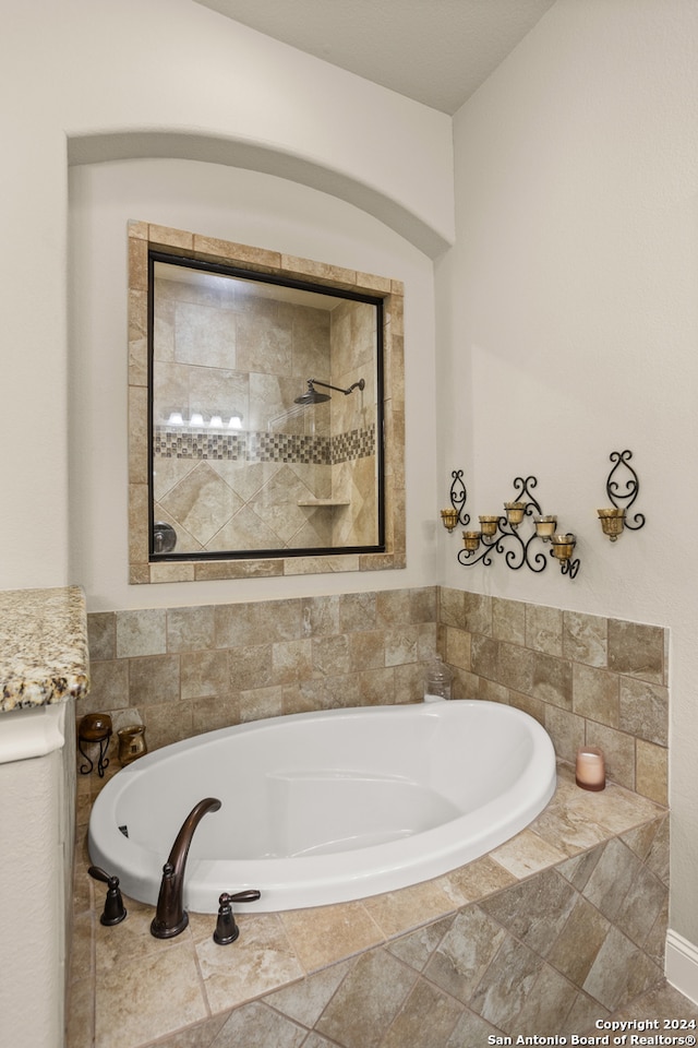 bathroom featuring a relaxing tiled bath