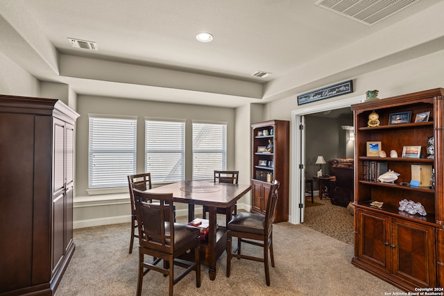 dining space featuring light carpet