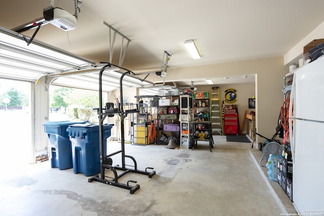 garage featuring white fridge and a garage door opener