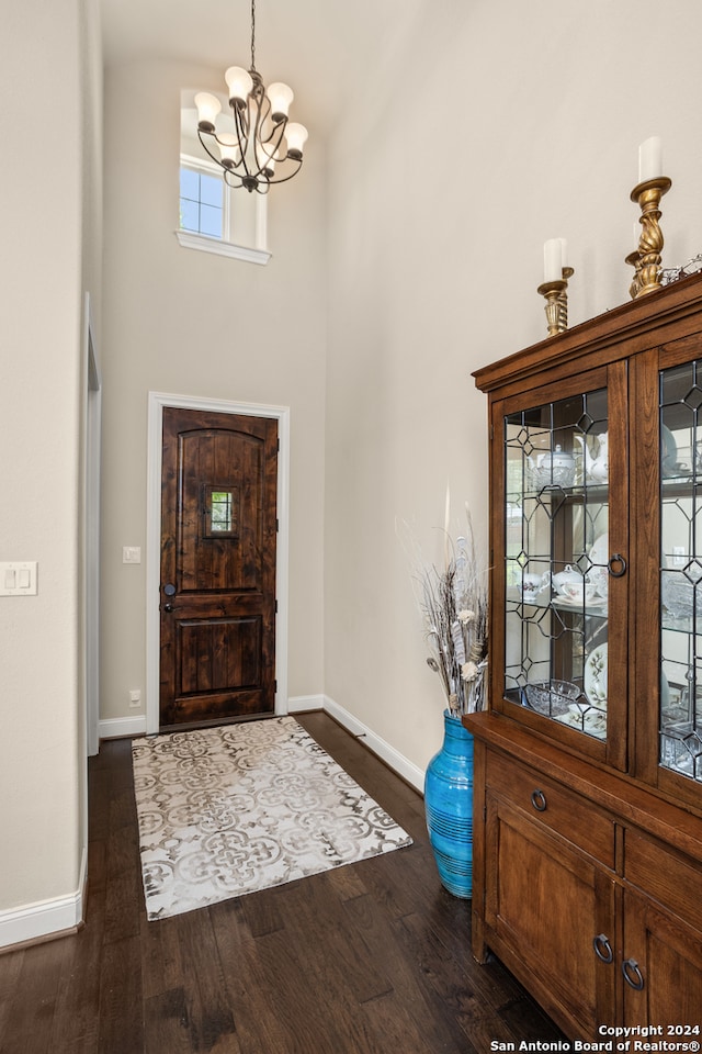 entrance foyer with dark hardwood / wood-style flooring, a high ceiling, and a chandelier