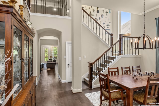 dining room with an inviting chandelier, crown molding, a high ceiling, and dark hardwood / wood-style floors