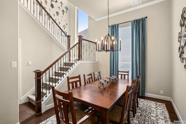 dining area featuring dark hardwood / wood-style flooring, ornamental molding, a wealth of natural light, and a chandelier