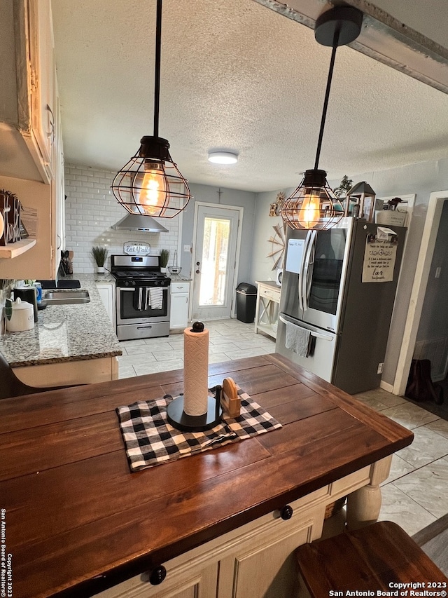 tiled dining area with sink and a textured ceiling