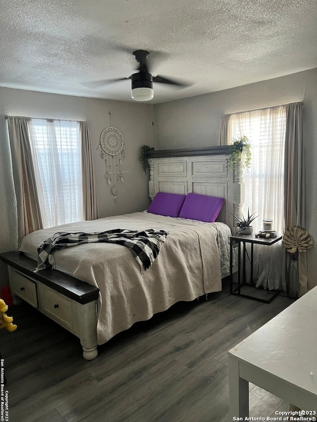 bedroom featuring dark hardwood / wood-style floors, a textured ceiling, and ceiling fan