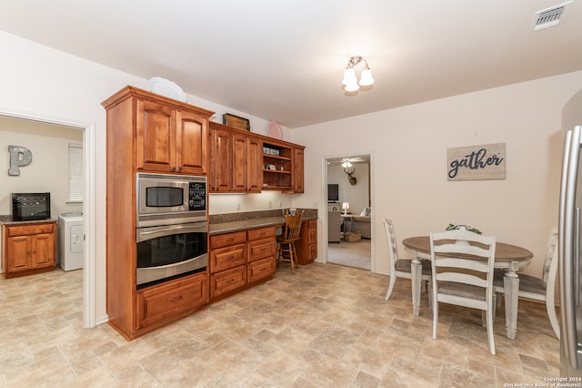 kitchen with light tile floors, stainless steel appliances, and washer / dryer