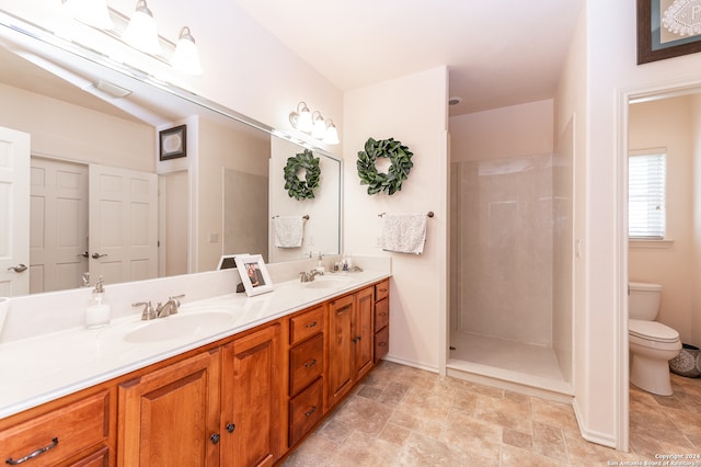 bathroom featuring a shower, tile floors, double sink, toilet, and vanity with extensive cabinet space