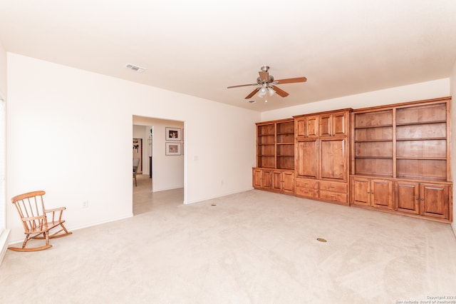 unfurnished living room featuring ceiling fan and light carpet