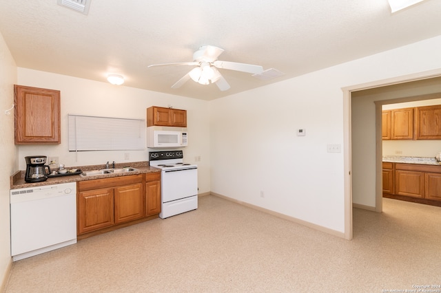 kitchen featuring ceiling fan, sink, white appliances, and light stone counters