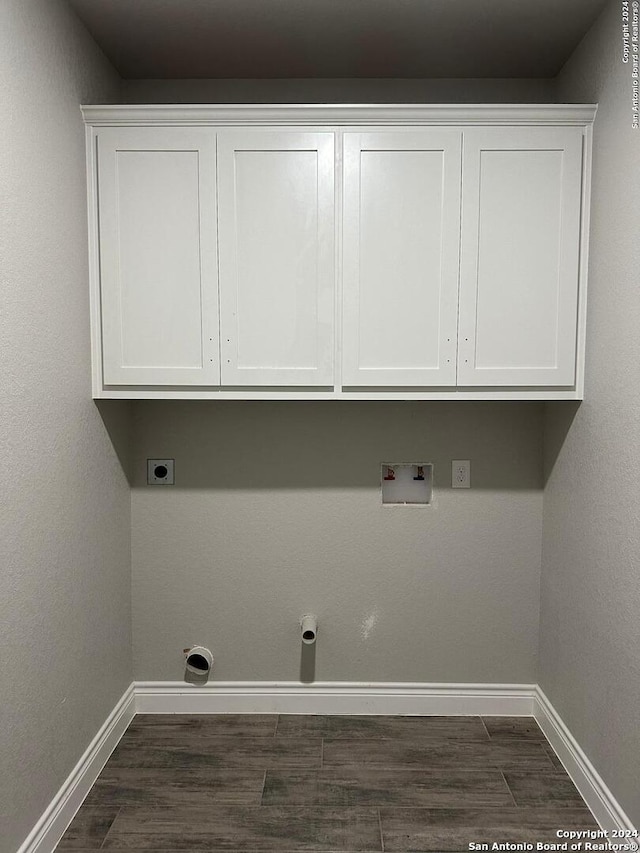 washroom featuring electric dryer hookup, dark wood-type flooring, hookup for a washing machine, and cabinets