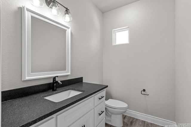 bathroom featuring vanity, toilet, and wood-type flooring