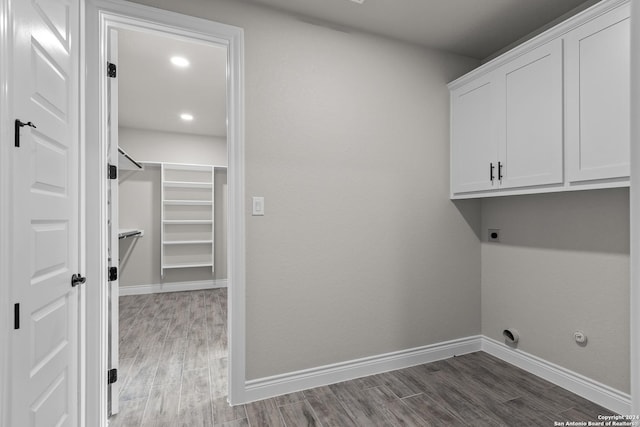 clothes washing area with cabinets, dark hardwood / wood-style floors, and electric dryer hookup