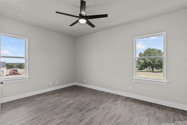 unfurnished room featuring ceiling fan and plenty of natural light