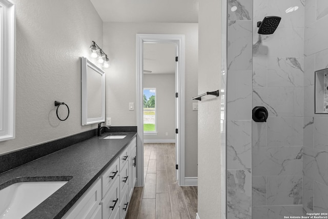 bathroom featuring tiled shower and vanity