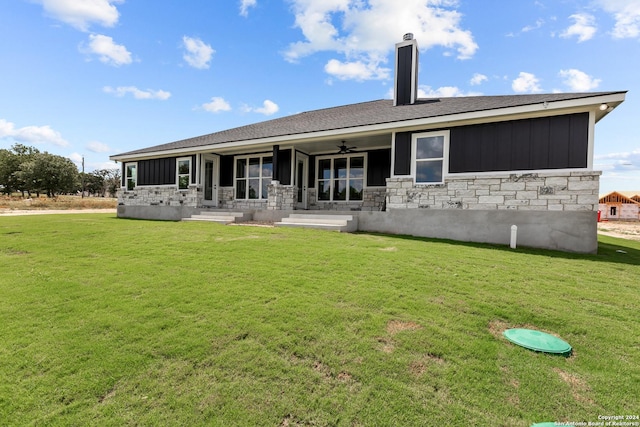 back of house with covered porch and a yard