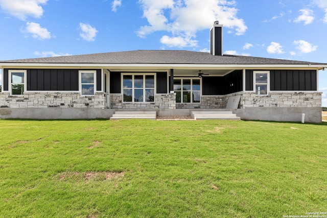 rear view of house featuring ceiling fan, a porch, and a yard