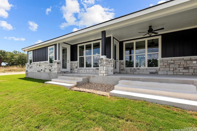 exterior space with ceiling fan, a porch, and a yard