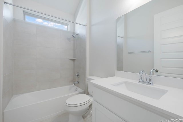 full bathroom featuring tiled shower / bath, vanity, and toilet