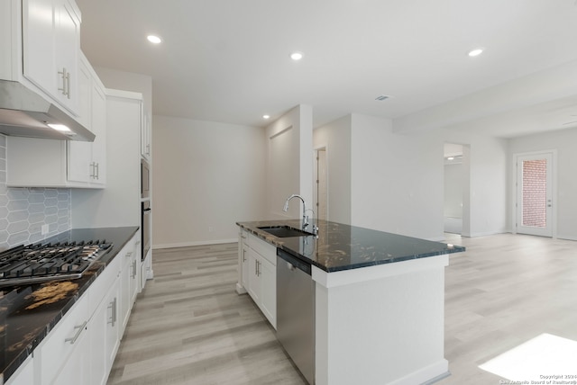 kitchen featuring appliances with stainless steel finishes, white cabinets, sink, and an island with sink