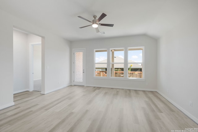 spare room with lofted ceiling, light wood-type flooring, and ceiling fan