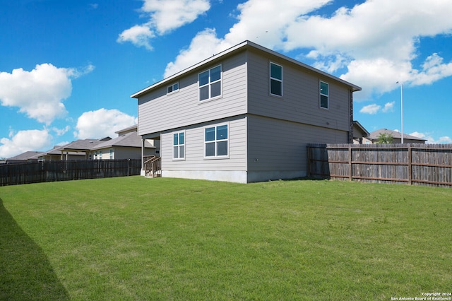 rear view of property featuring a lawn